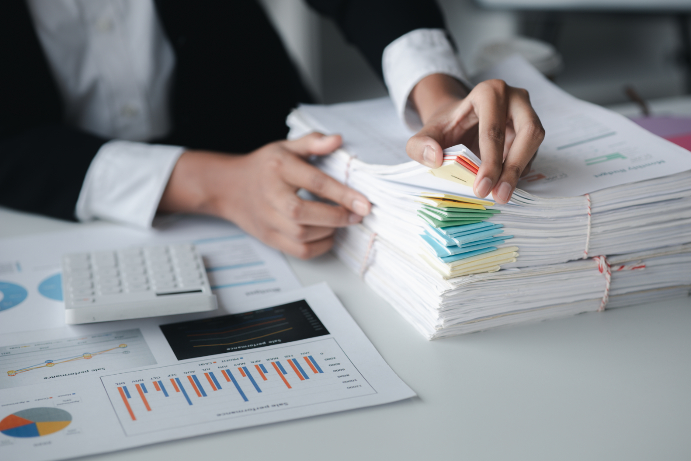 How Bookkeeping Impacts Business Growth businessman looking through stacks of papers on de rrg587r (1)